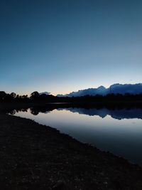 Scenic view of lake against clear sky during sunset