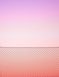 Fence against sky during sunset