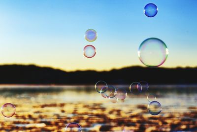 Close-up of bubbles over river against sky