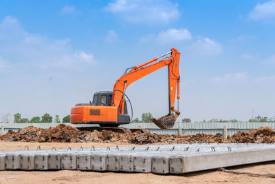 Excavator dig soil for adjust ground and pile of concrete plie at a construction site