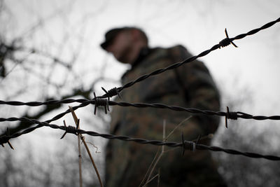 Close-up of barbed wire fence on field