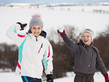 Siblings playing with snow