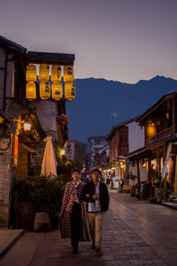 People walking on illuminated building at night