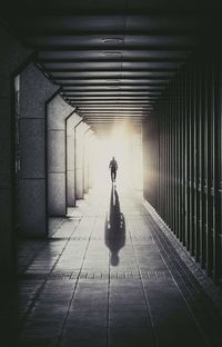 Rear view of woman walking in illuminated building