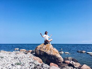 Woman on beach against clear blue sky