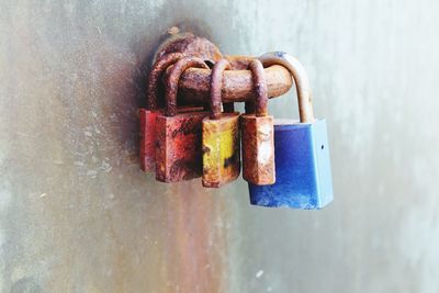 Close-up of old rusty padlocks hanging on metal