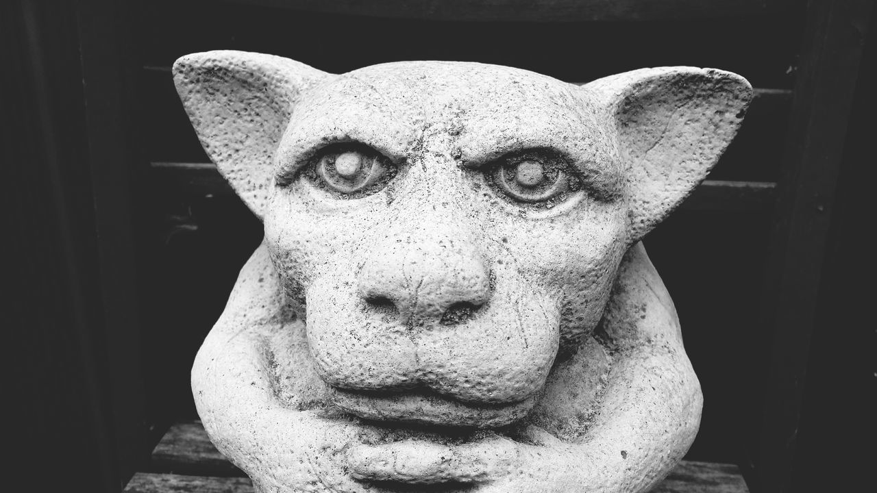 CLOSE-UP PORTRAIT OF OLD STATUE AGAINST WALL