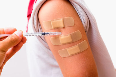 Midsection of woman with iv drip against white background