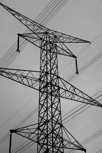 Low angle view of electricity pylon against clear sky