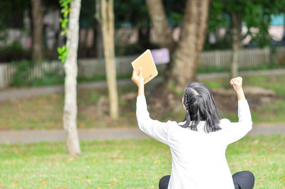 Rear view of woman standing on field