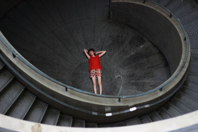 High angle view of young woman lying amidst staircase
