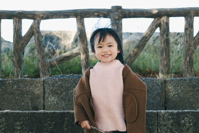 Portrait of smiling young woman standing outdoors