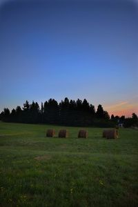 Hay bales on field against sky