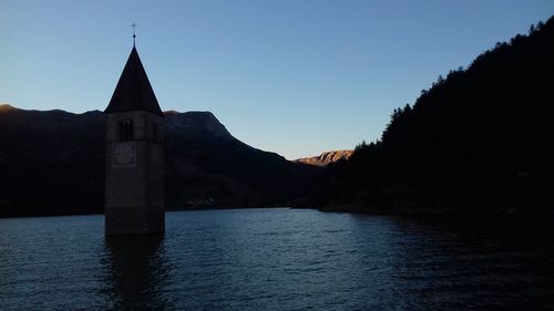 Scenic view of river by buildings against clear sky