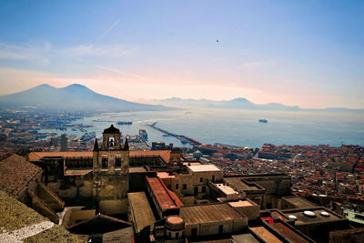 High angle view of town by sea against sky