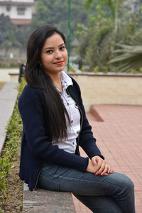 Portrait of young woman sitting outdoors