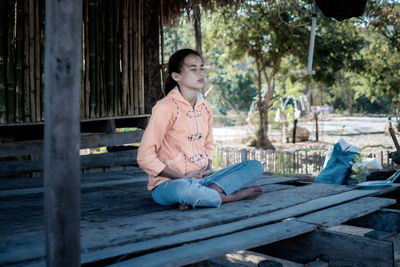 Girl meditating with eyes closed mind training in a quiet old wooden house