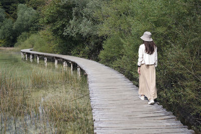 Rear view of woman walking on bridge