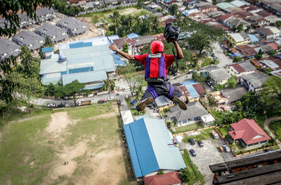 Man skydiving over buildings in city