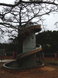 Sculpture of bare tree against built structure