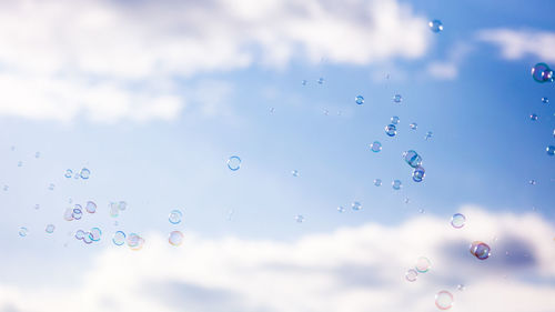 Low angle view of bubbles against sky during rainy season