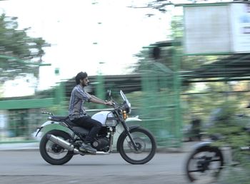 Side view of man riding bicycle on road