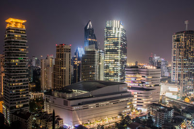 Illuminated buildings in city against sky at night