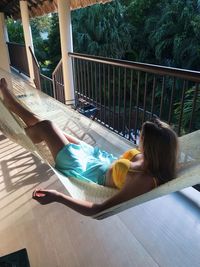 Young woman relaxing in hammock at balcony