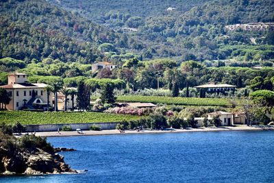 Buildings by sea against mountain