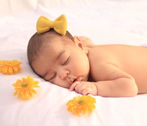 Close-up of baby girl lying on bed