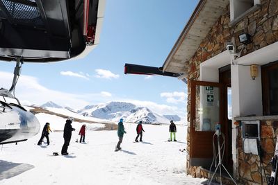 People on snowcapped mountain against sky