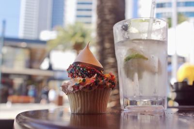 Close-up of cupcake with lemonade on table at sidewalk cafe