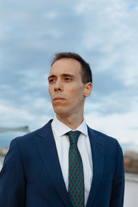 Portrait of young man standing against sky