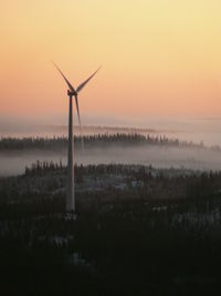 Wind turbines on field at sunset