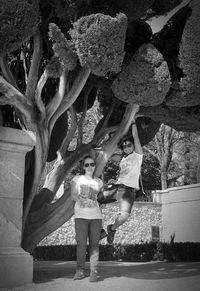 Full length of woman standing by tree