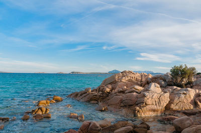 Rocks on sea shore against sky