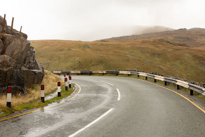 Road leading towards mountain against sky