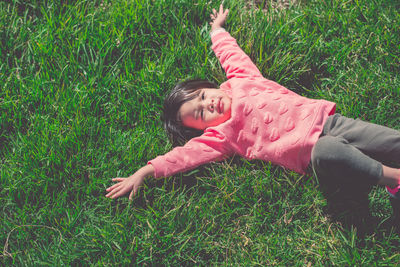 Low section of woman lying on grassy field