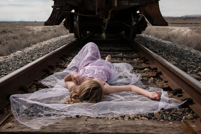 Frontal view of woman lying on a railway track