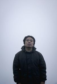 Young man looking away against white background