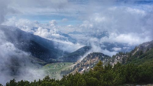 Scenic view of foggy mountains against sky