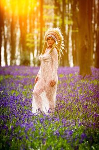 Woman standing with flowers in field