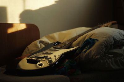 Close-up of guitar on bed