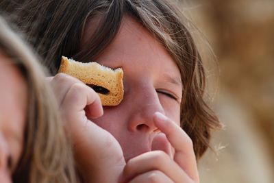 Close-up of boy looking through piece of bread