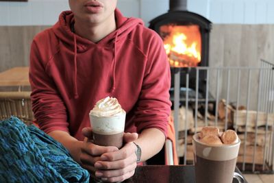 Midsection of man holding coffee cup