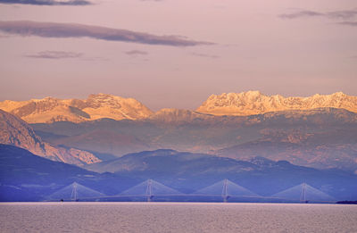 Scenic view of bridge over river against snowcapped mountains 