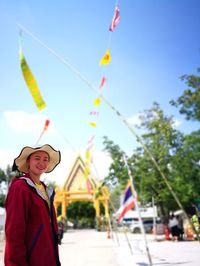 Smiling woman standing on road against sky