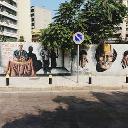 Graffiti on wall against trees in city