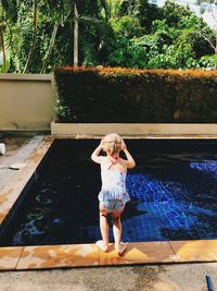 Full length of girl standing by swimming pool