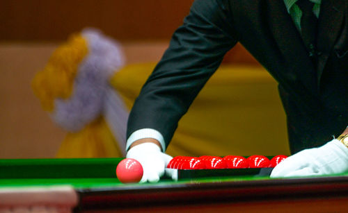 Midsection of man arranging balls on pool table